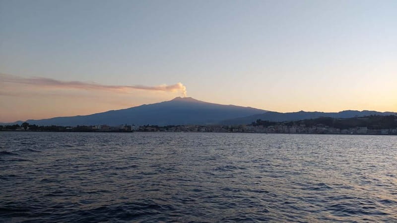 Giardini Naxos Taormina: Dolphin Watching Sunset Tour - Isola Bella and the Taormina coastline, seen from a boat stop that actually matters